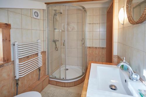 uma casa de banho com um chuveiro e um lavatório. em Apartament ze słoneczną werandą -250 m do plaży em Sopot