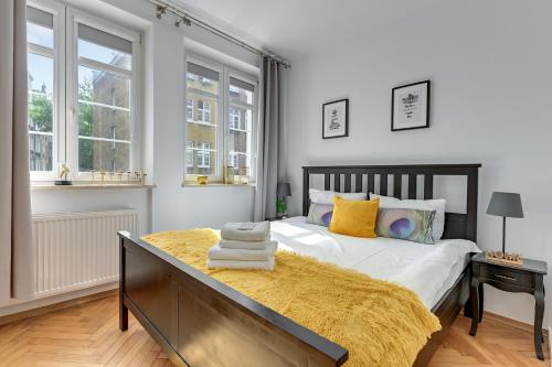 1 dormitorio con 1 cama grande con almohadas amarillas en GEDANUM Apartment OLD TOWN CENTER St.Marry Church, en Gdansk