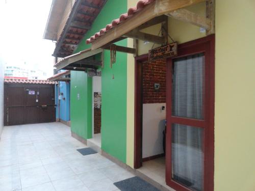 a building with green walls and a red door at Studio Imbé in Imbituba