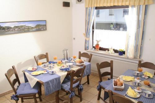 uma sala de jantar com mesas e cadeiras com comida em Haus-Anka em Cochem