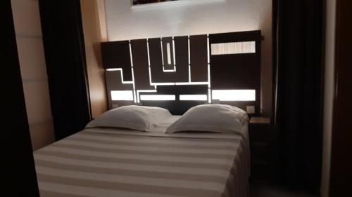 appartement Callebasse في كايان: غرفة نوم مع سرير مع اللوح الأمامي الأسود والأبيض