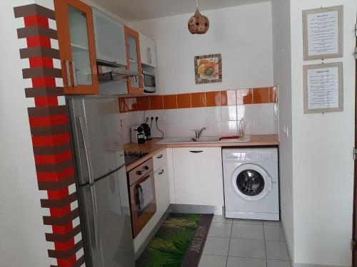 a small kitchen with a washing machine in it at appartement Callebasse in Cayenne