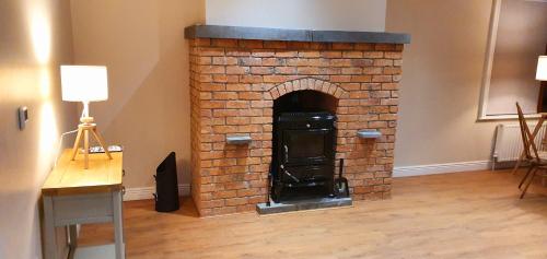a brick fireplace in a living room with a lamp at Riverside Marina Apartments in Lanesborough