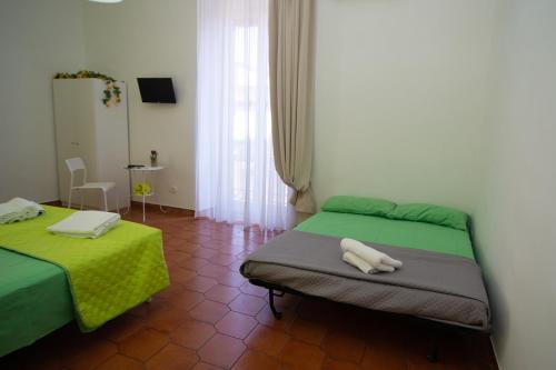 ナポリにあるB&B Tarumbòのベッドルーム(緑のシーツを使用したベッド2台付)