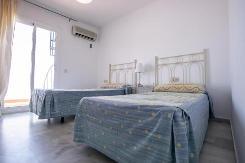 a bedroom with two beds with blue and yellow sheets at Vistamojacar in Mojácar