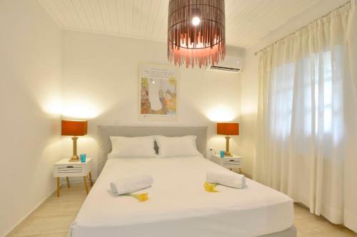 a bedroom with a large white bed with two lamps at Jerry Afro in Kanálion