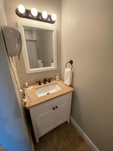 a bathroom with a sink and a mirror at Twin Lakes Creamery, Grill & Inn in Leitchfield