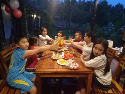 a group of children sitting around a table eating food at Bebe Homestay Phu Quoc in Phu Quoc