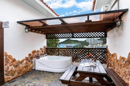 a bathroom with a tub and a large window at Red Praha Pension in Geoje