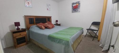 1 dormitorio con 1 cama con edredón verde en Departamento por día en Arica, en Arica