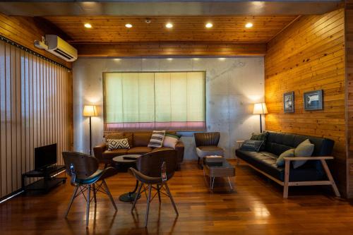 a living room with a couch and chairs at Guesthouse Senaga in Gushi