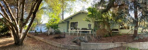 una pequeña casa verde en medio de árboles en Kin House Guest Suite, en Oakhurst