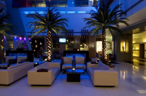 a lobby with white couches and palm trees at night at The Regenza By Tunga in Navi Mumbai