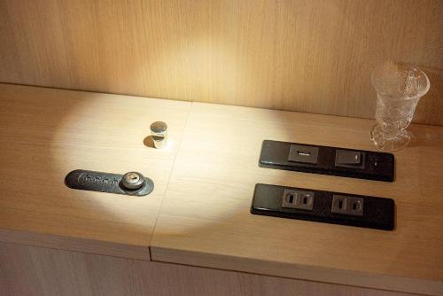 two remote controls sitting on a wooden table at plat hostel keikyu asakusa station in Tokyo