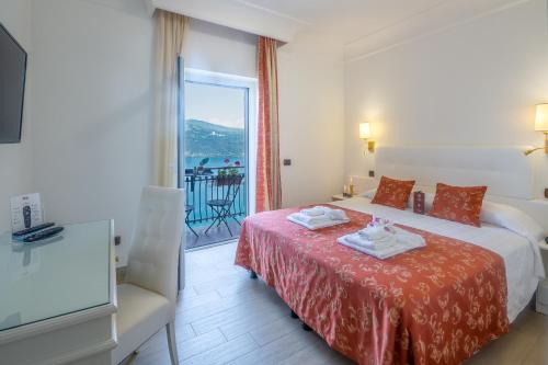 Habitación de hotel con cama y balcón en Hotel Castel Gandolfo en Castel Gandolfo