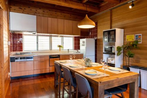 a kitchen with a large wooden table with chairs at Guesthouse Senaga in Gushi