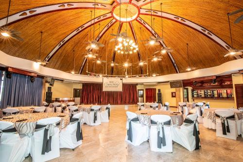 a banquet hall with tables and chairs and a chandelier at Hotel Casa Roland Golfito Resort in Golfito