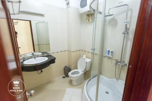 a bathroom with a shower and a toilet and a sink at The Queen Hotel & Spa in Hanoi