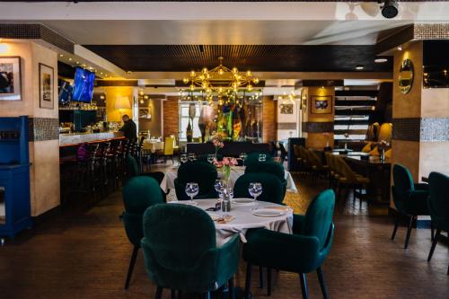 a dining room with tables and chairs and a chandelier at Hotel Olympic in Khabarovsk