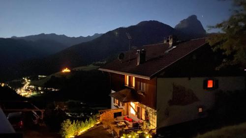 a night view of a building with mountains in the background at Fless in San Martino in Badia