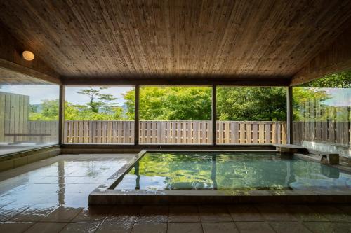 a swimming pool in a house with a wooden ceiling at Hakone Retreat Före in Hakone