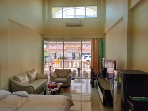 a room with a bed and a couch and a table at โฮมสเตย์ เมืองไทยฟิตเนส อารีนา in Ban Bo Nam