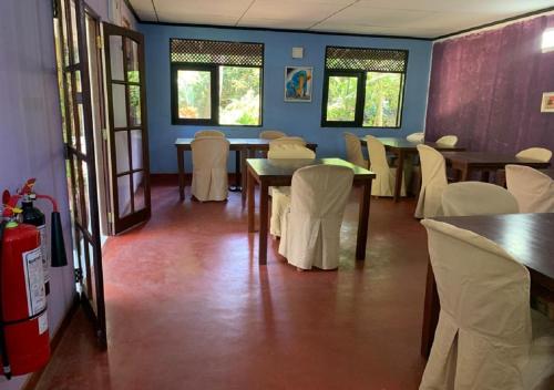 a dining room with tables and white chairs at Palm Beach Inn & Sea Shells Cabanas in Bentota