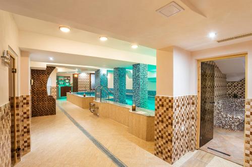 a bathroom with a tub and a shower with blue tiles at Family Hotel Romantika in Velingrad
