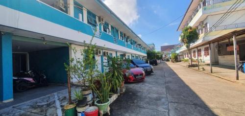 Rumah Dempo Syariah في Sungaidurian: شارع فيه سيارات تقف بجانب مبنى