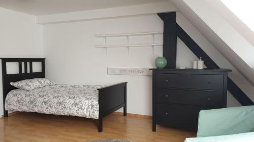 a bedroom with a black bed and a dresser at Samostan Mekinje in Kamnik