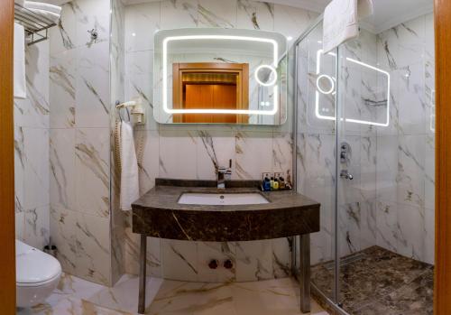a bathroom with a sink and a mirror and a toilet at Regno Hotel in Istanbul