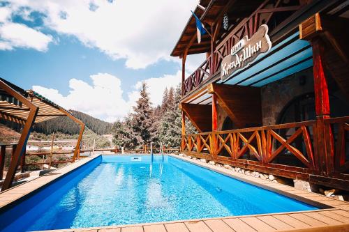 a swimming pool in front of a building at Chalet CrepDeChine Hotel in Bukovel