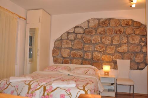 a bedroom with a bed and a stone wall at Apartments Lucic in Dubrovnik