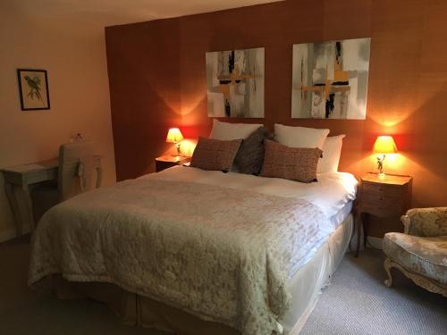 a bedroom with a bed with two lamps and a chair at Manoir du Bois Mignon in Le Fleix
