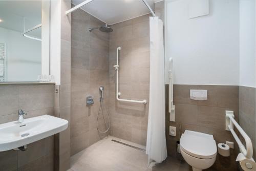 W łazience znajduje się prysznic, toaleta i umywalka. w obiekcie Stadthotel Lohne, Self Check In, mit Bäckerei und Cafe w mieście Lohne