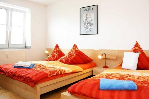 a bedroom with two beds with red pillows at City Apartments Cologne - Apartment 2 in Cologne