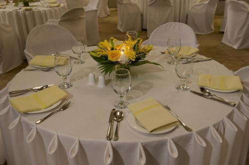 a table with a white table cloth and yellow flowers on it at The Regenza By Tunga in Navi Mumbai