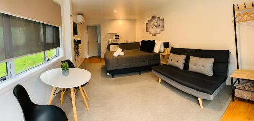 a living room with a couch and a table at Racecourse Motel in Paeroa