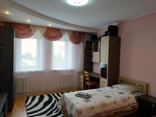 a bedroom with a bed and a desk and a window at Большая квартира с кондиционером на пр Ленина in Vladimir