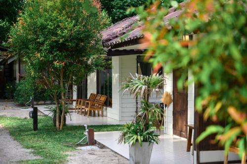 a house with a table and chairs in the yard at Wapi Resort in Ko Lipe