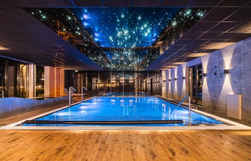a pool in a hotel with a star ceiling at Caryńska Resort & SPA in Lutowiska