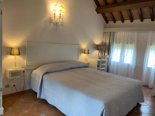 a bedroom with a white bed and two lamps at Princess Art Hotel in Ferrara