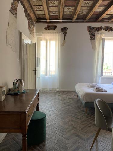 a bedroom with a bed and a desk and window at Residenza Giulio Romano in Mantova