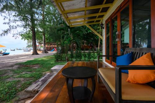 a porch of a house with a table and a bench at Wapi Resort in Ko Lipe