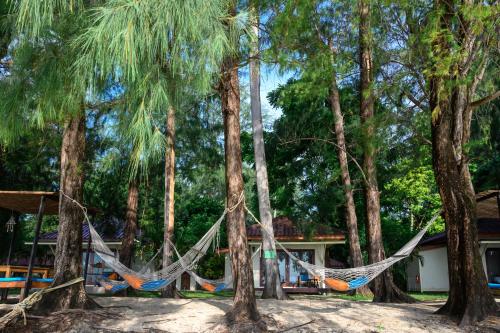 a hammock in the trees in front of a house at Wapi Resort in Ko Lipe