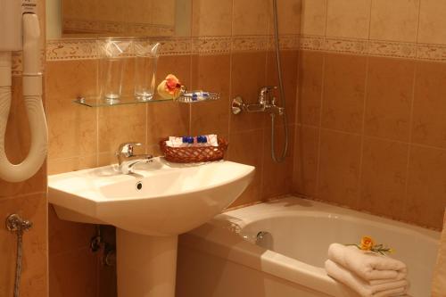uma casa de banho com um lavatório e uma banheira com um lavatório. em Joya Park Hotel em Golden Sands