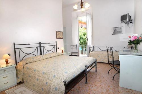 een slaapkamer met een bed, een dressoir en een raam bij Hotel Palace in Levanto