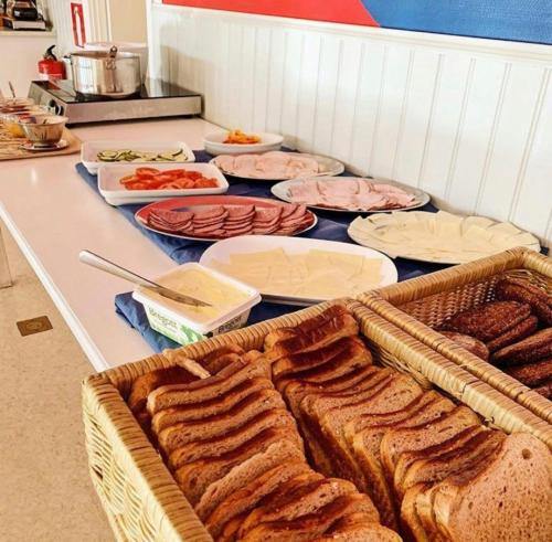 einen Tisch mit einem Haufen Brot und anderen Lebensmitteln in der Unterkunft Övernäsgården Gästhem in Mariehamn