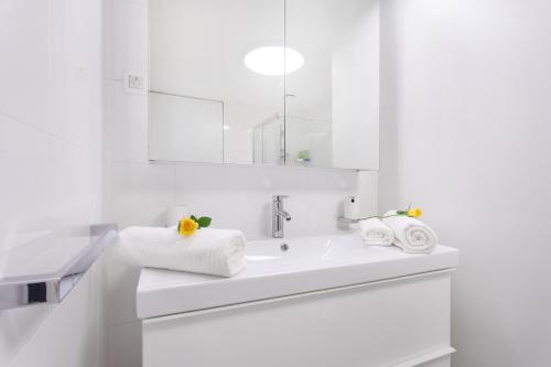 a white bathroom with a sink and a mirror at Apartments Poklukar Bled in Bled