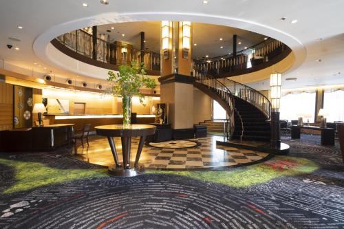 a lobby with a spiral staircase in a building at Kanazawa New Grand Hotel Prestige in Kanazawa